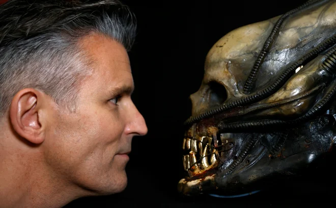 Stephen Lane, izvršni direktor Prop Store, se fotografira z mehansko glavo iz filma <em>Alien </em>pred začetkom dražbe filmskih rekvizitov v Rickmansworthu v Veliki Britaniji. FOTO: John Sibley/Reuters