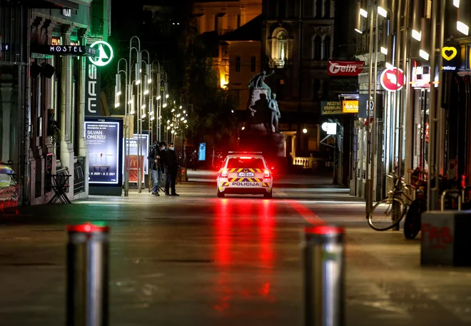 Torkov večer, ko je začel veljati ukrep o omejitvi gibanja med 21. in 6. uro. Na fotografiji je policijska kontrola na Čopovi ulici v Ljubljani. FOTO: Matej Družnik/Delo