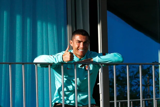 Cristiano Ronaldo je najprej pomahal svojim privržencem na Portugalskem, kjer se je okužil s covidom-19, nato pa odletel v Italijo, da bi se pripravil za snidenje z Lionelom Messijem. FOTO: Diogo Pinto/AFP