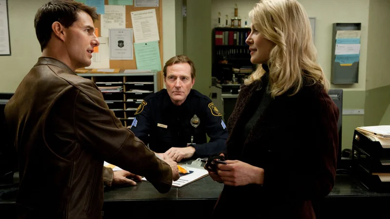 Fotografija: V prvem filmu o Jacku Reacherju je bil ponesrečeni naslovni junak Tom Cruise (na fotografiji levo, desno soigralka Rosamund Pike, na sredini pa avtor knjig Lee Child, ki je odigral mini vlogo policista). FOTO: Dokumentacija Dela