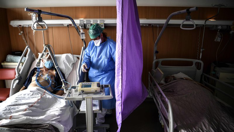 Fotografija: V zdravniških združenjih so opozorili, da je zaradi pomanjkanja zaščitnih oblek in mask na začetku krize umiralo zdravniško osebje, in zatrdili, da se je vlada zavedala nevarnosti, a ni ustrezno ukrepala. FOTO: Christophe Archambault/AFP