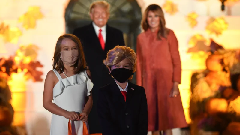Fotografija: Melania in Donald Trump med praznovanjem noči čarovnic pozirata pred Belo hišo z mladima dvojnikoma.
Foto Olivier Douliery/Afp