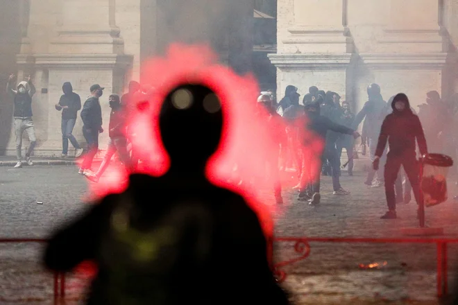 Tudi na torkov večer so se nadaljevali nasilni protesti. Na fotografiji protest skrajnih desničarjev med spopadom s policijo v Rimu. FOTO: Guglielmo Mangiapane/ Reuters