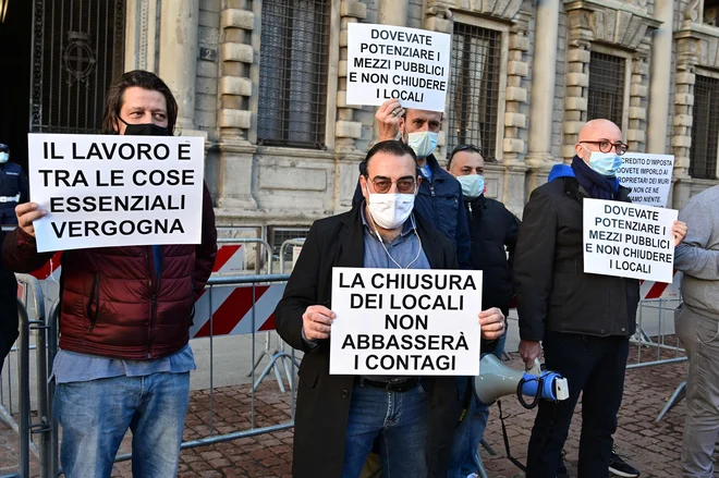 Lastniki restavracij pred mestno hišo v Milanu, kjer demonstrirajo proti ukrepom vlade zaradi novih omejitev za zajezitev drugega vala koronavirusa. »Zapiranje obratov ne zmanjša okužb«, »Morali bi okrepiti javni prevoz in ne zapirati obratov«, »Delo je ključno«, je le nekaj sporočil, ki so jih namenili oblastem. FOTO: Miguel Medina/Afp