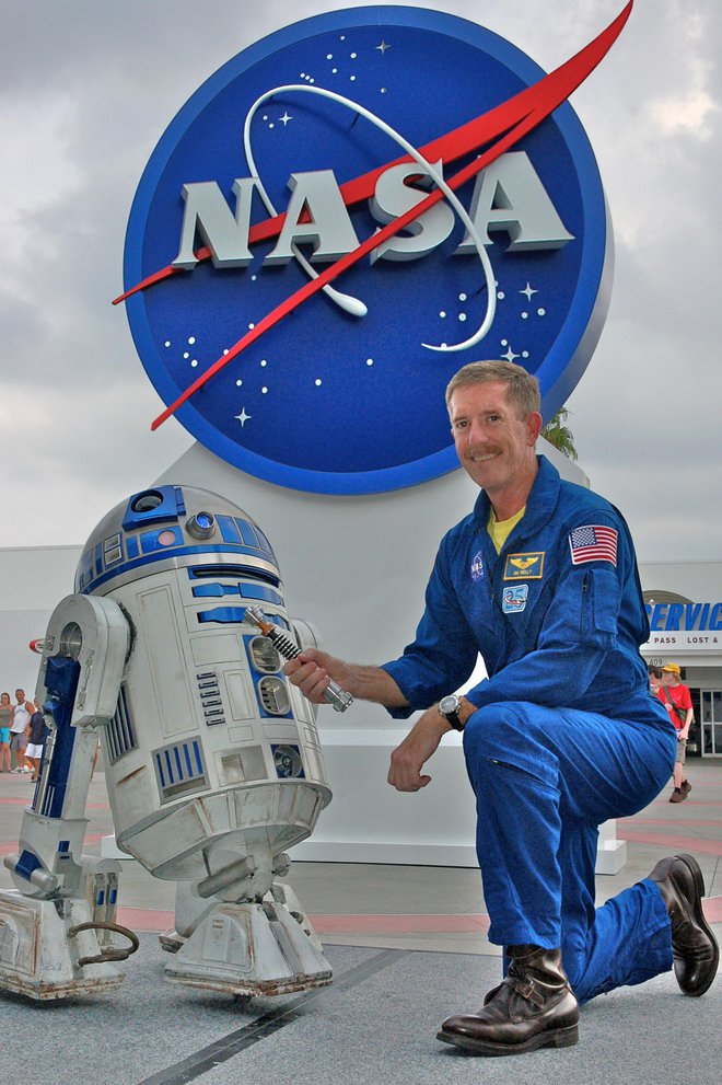 Astronavt Jim Reilly z R2-D2 in Skywalkerjevim svetlobnim mečem v Kennedyjevem vesoljskem centru. FOTO: Lucasfilm/Nasa