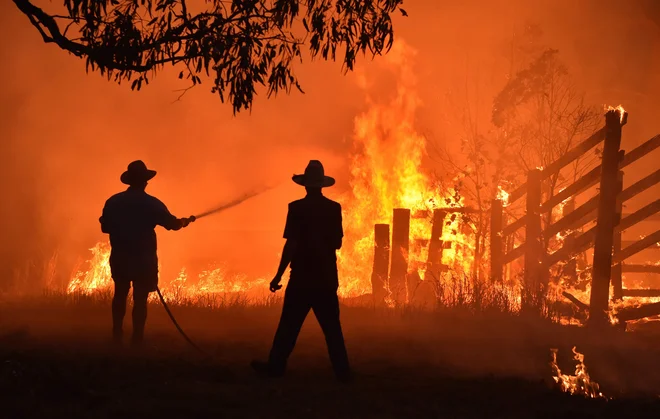 V kraju Hillsville blizu mesta Taree, 350 km severno od Sydneyja prebivalci branijo nepremičnino pred požarom. FOTO:Peter Parks/Afp<br />
&nbsp;