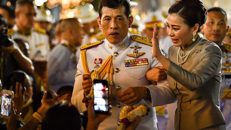 Fotografija: Tajski kralj Maha Vajiralongkorn in kraljica Suthida pozdravljata rojalistične pristaše pred Veliko palačo v Bangkoku, potem ko sta predsedovala verski slovesnosti v budističnem templju v palači. FOTO: Lillian Suwanrumpha/Afp