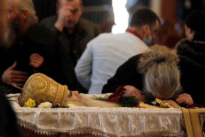 Šokantni prizori vernikov brez zaščitnih mask, ki so v mimohodu poljubljali truplo metropolita Amfilohija v odprti krsti.<br />
FOTO: Stevo Vasiljević/Reuters