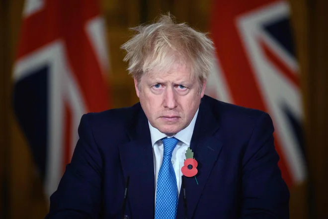 Britanski premier Boris Johnson je na virtualni tiskovni konferenci v Londonu včeraj podal izjavo o trenutni statistiki koronavirusa ter testiranju in ukrepih zaklepanja, ko so v Angliji uvedene nove omejitve, da bi omejili naraščajoče okužbe. Mestna središča na otoku so se včeraj ponovno postala mesta duhov. FOTO: Leon Neal/Afp