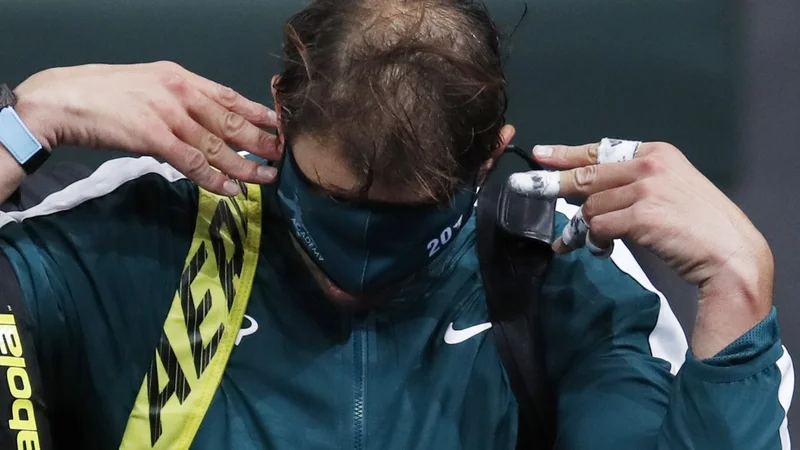 Fotografija: Rafael Nadal se je po porazu skril za masko. FOTO: Gonzalo Fuentes/Reuters