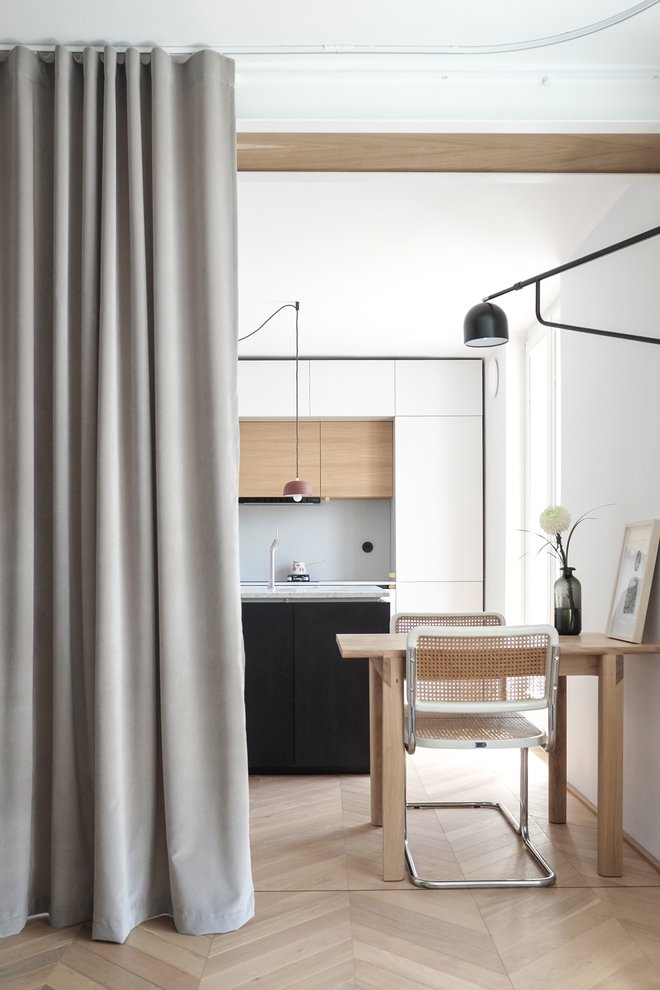 V stanovanje so umestili zaveso, ki ima funkcijo ločevanja prostora, in sicer spalnice in kuhinje, hkrati pa se lahko uporabi tudi za zastiranje okna.