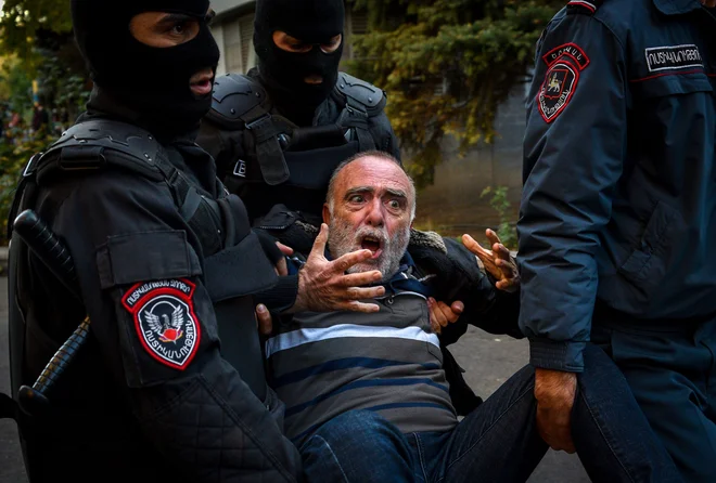 Nedavnega mirovnega sporazuma, ki je v Gorskem Karabahu­ zaustavil krvave spopade med Armenijo in Azerbajdžanom, niso razglasili za »armensko kapitulacijo« zgolj v Bakuju. O tem je prepričan tudi večtisočglava množica­ demonstrantov v Erevanu, ki zahteva odstop »izdajalskega premiera« Nikola Pašinjana. Posredovala je policija, ki je aretirala več ljudi. FOTO: Afp