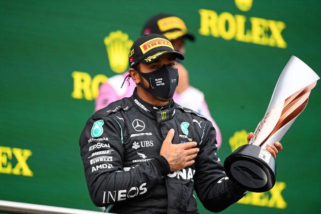 Lewis Hamilton z zmagovalnim pokalom. FOTO: Clive Mason/AFP