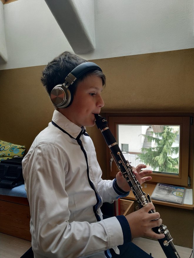 Lenart Dolinar, ki že peto leto igra klarinet, meni, da tudi pri pouku na daljavo glasbeno napreduje v enakem tempu kot prej. FOTO: osebni arhiv