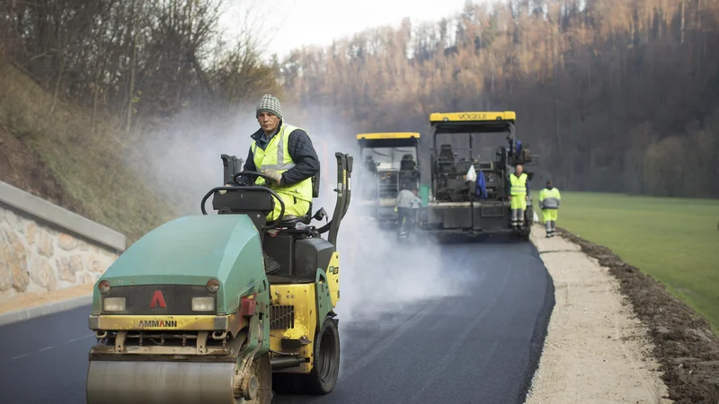 Fotografija: Polaganje finega sloja asfalta v Logu pri Polhovem Gradcu. FOTO: Jure Eržen/Delo