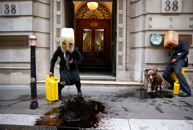 Aktivisti podnebne akcijske skupine Ocean Rebellion izvajajo protestno akcijo pred stavbo Baltic Exchange v Londonu. FOTO: Henry Nicholls/Reuters<br />
<br />
&nbsp;