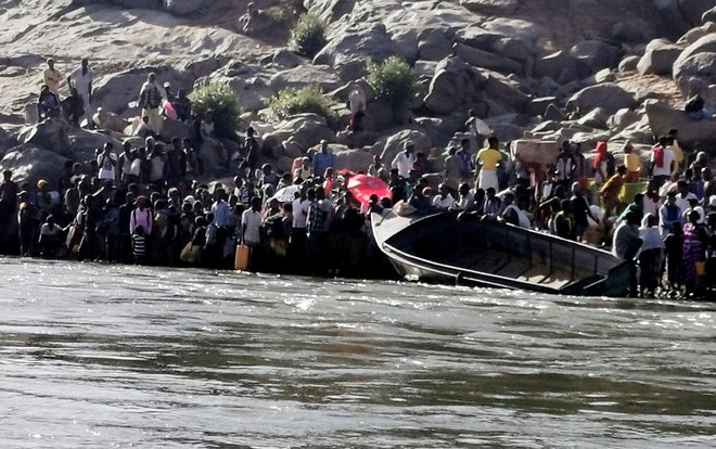 Etiopski begunci poskušajo prečkati reko, ki razmejuje Etiopijo in Sudan. FOTO: El Tayeb Siddig/Reuters