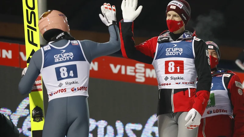 Fotografija: Takole sta si za prestižno zmago v uvodni tekmi čestitala Avstrijca Michael Hayboeck in Stefan Kraft. FOTO: Kacper Pempel/Reuters