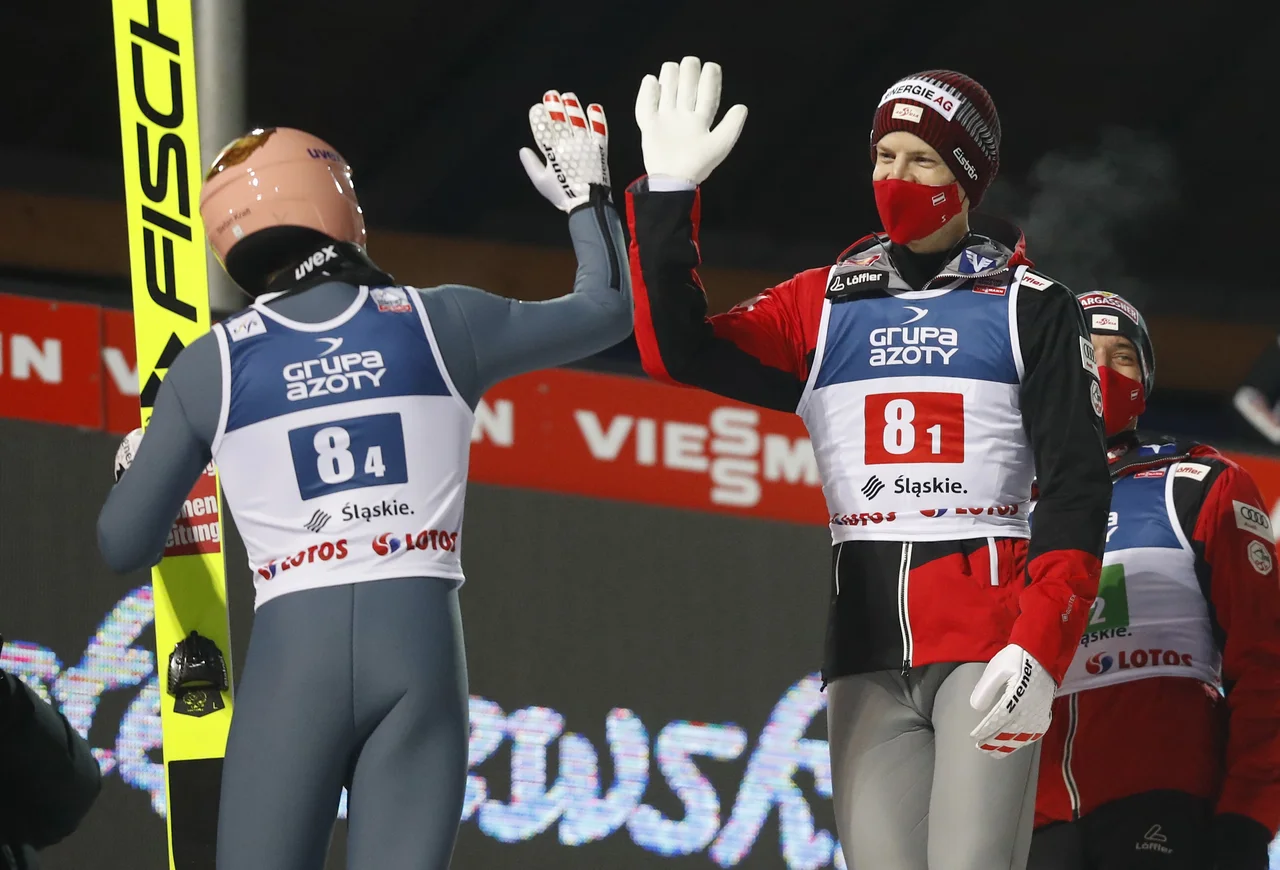 Fotografija: Takole sta si za prestižno zmago v uvodni tekmi čestitala Avstrijca Michael Hayboeck in Stefan Kraft. FOTO: Kacper Pempel/Reuters