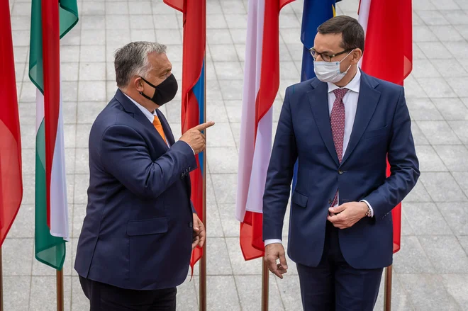 Poljski premier Mateusz Morawiecki (desno) in njegov madžarski kolega Viktor Orbán sta znova zavrnila uredbo o pogojevanju izplačil z delovanjem pravne države. FOTO: Wojtek Radwanski/AFP