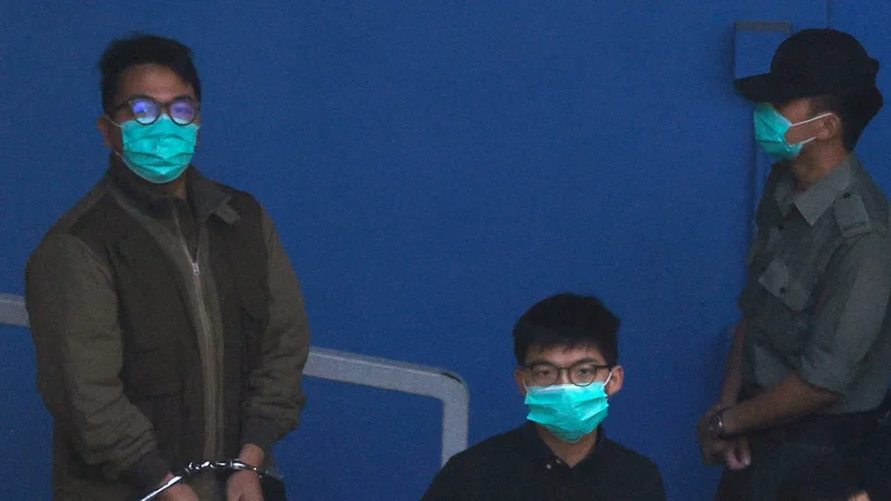 Fotografija: Trije aktivisti (na fotografiji Ivan Lam in Joshua Wong) so prejšnji teden prebili v samicah, v katerih je bila luč prižgana 24 ur na dan; to je bila napoved, da jih bodo med prestajanjem zaporne kazni obravnavali kot »nevarnost«, ki jo je treba psihično zlomiti. FOTO: Tyrone Siu/Reuters