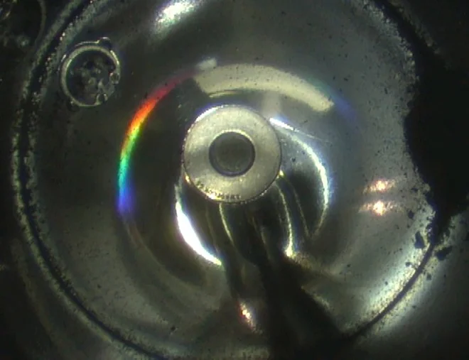 Črni material na desnem robu je vzorec z Rjuguja. Glavno posodo z vzorcem morajo še odpreti. FOTO: Jaxa/AFP