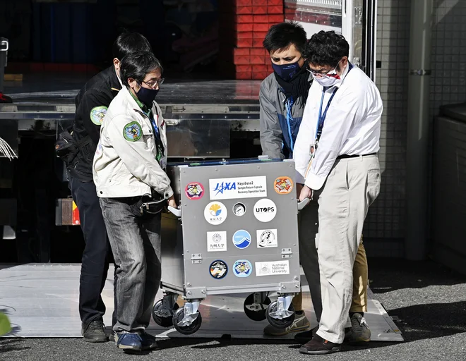 Kapsulo odpirajo v znanstvenem centru v Sagamihari na Japonskem. FOTO: Kyodo/Reuters