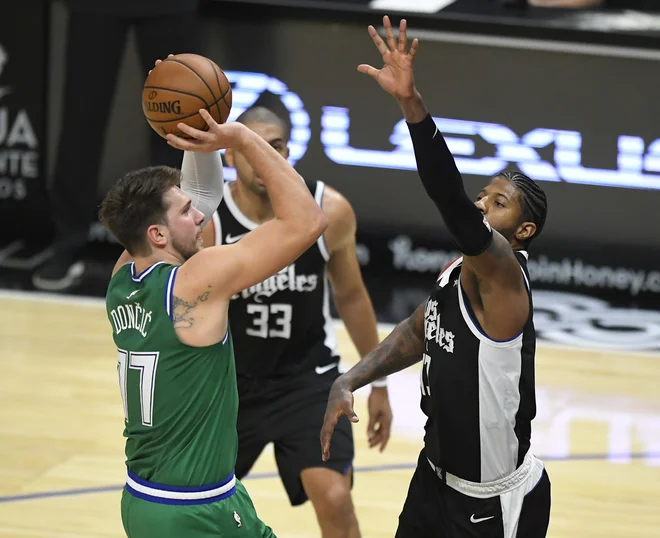 Najboljša strelca Luka Dončić (v zelenem) in Paul George med eno od akcij. FOTO: John Mccoy/AFP