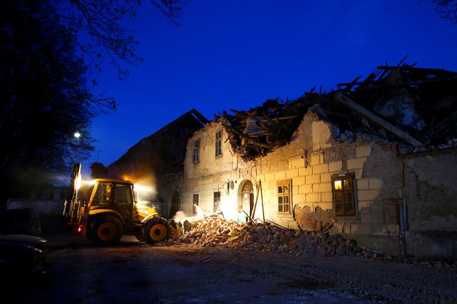 Čiščenje porušene stavbez buldožerjem po potresu v Petrinji. FOTO: Antonio Bronic/Reuters