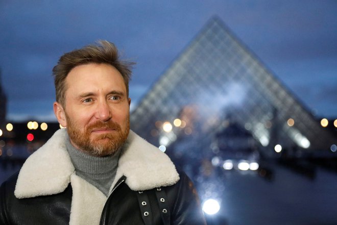 K poslušanju po spletu in plesanju nocoj iz Pariza vabi dobrodelni nastop francoskega didžeja Davida Guette pred louvrsko piramido. Foto Charles Platiau/Reuters