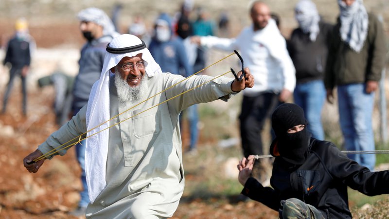 Fotografija: Palestinci so se s fračami zoperstavili izraelski vojski med protestom proti gradnji izraelskih naselij v Deir Jarirju, na zasedenem Zahodnem bregu. FOTO: Mohamad Torokman/Reuters