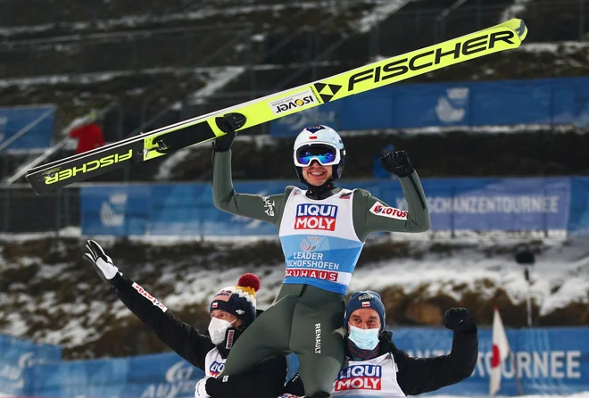 Poljaka Dawid Kubacki (levo) in Piotr Zyla (desno) sta takole dvignila na rame rojaka Kamila Stocha, velikega zmagovalca 69. novoletne turneje v smučarskih skokih. FOTO: Lisi Niesner/Reuters