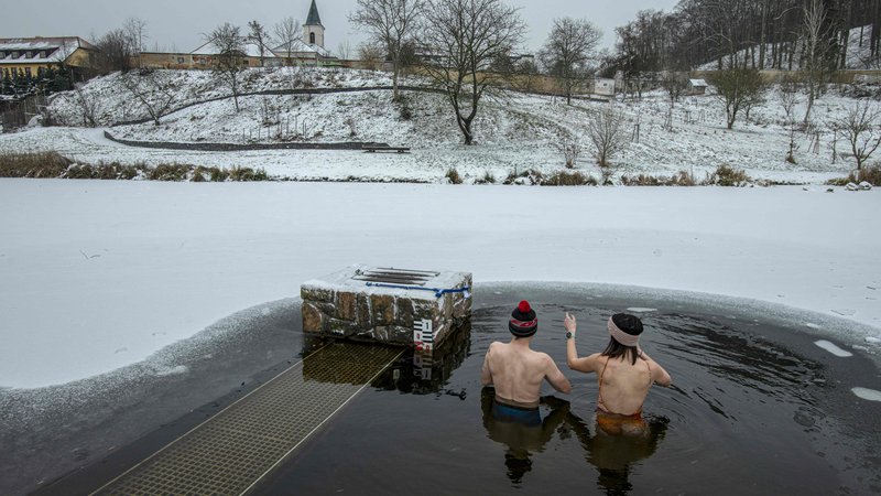 Fotografija: Češki pogumneži so se v Pragi potopili v ledeno vodo ribnika Terezka v parku. FOTO: Michal Cizek/Afp