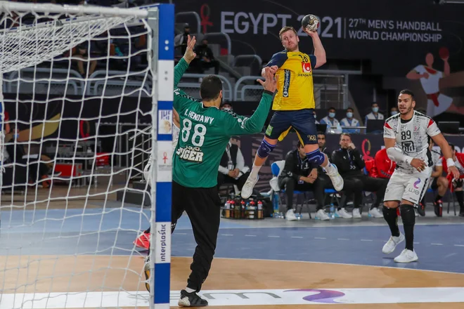 Švedski rokometaši (v akciji Linus Persson) so danes tesno ugnali gostitelje SP. FOTO: Mohamed Abd El Ghany/AFP
