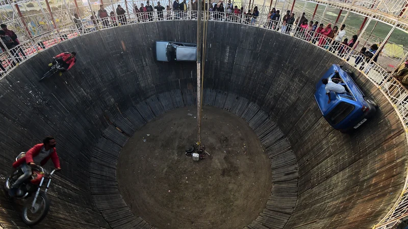 Fotografija: Na festivalu Magh Mela v Allahabadu so kaskaderji z avtomobili in motorji izvajali neverjetne vragolije na tako imenovanem zidu smrti. FOTO: Sanjay Kanojia/Afp