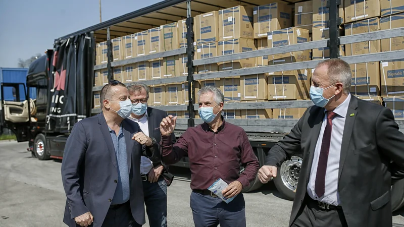 Fotografija: Tako so se aprila lani ob prvih pošiljkah zaščitne opreme s Kitajske slikali Joc Pečečnik, Marko Bitenc, tedanji zdravstveni minister Tomaž Gantar in gospodarski minister Zdravko Počivalšek. FOTO: Blaz Samec/Delo