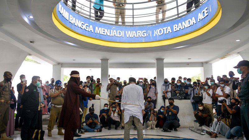 Fotografija: V Banda Acehu je član šeriatske policije s palico iz ratana javno prebičal človeka, ki so ga obtožili homoseksualnega seksa. Aceh je edina regija v Indoneziji, največji muslimanski državi, ki vsiljuje šeriatski islamski zakon. FOTO: Chaideer Mahyuddin/Afp