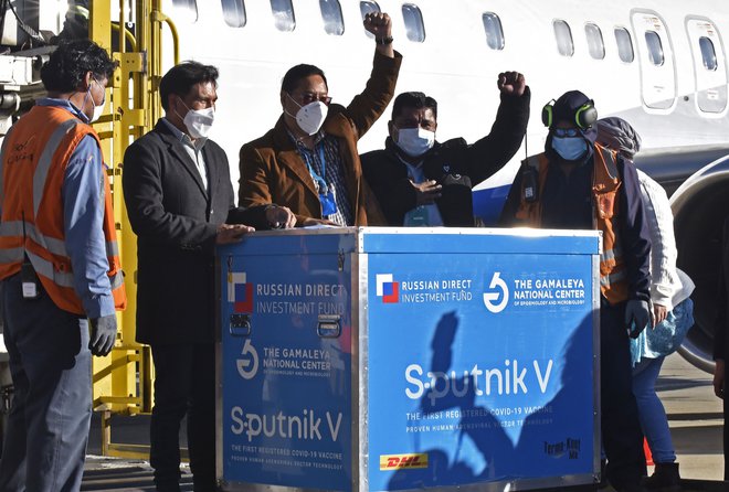 Bolivijski predsednik Luis Arce (sredina) je sprejel prvo pošiljko ruskega cepiva sputnik V. FOTO: Aizar Raldes/AFP