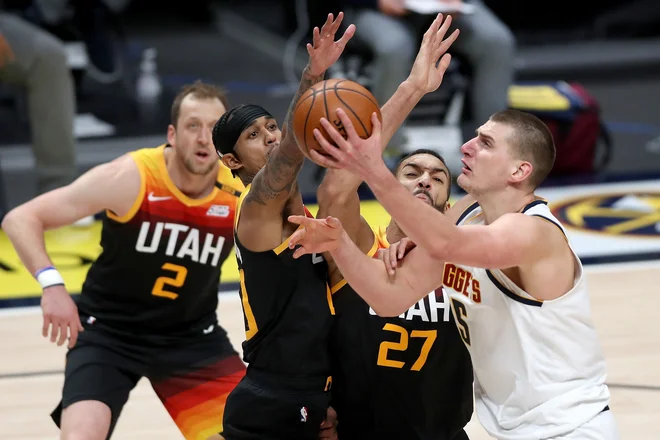Nikola Jokić (z žogo) se vedno potrudi v dvobojih s Francozom Rudyjem Gobertom (27). FOTO: Matthew Stockman/AFP