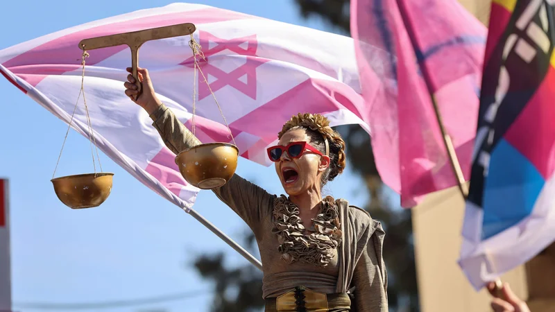 Fotografija: Protestnica na demonstracijah pred okrožnim sodiščem v Jeruzalemu, kjer poteka sojenje izraelskemu premierju Benjaminu Netanyahuju zaradi suma korupcije. FOTO: Emmanuel Dunand/Afp