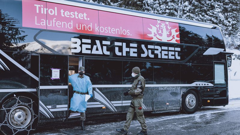 Fotografija: Avstrijski vojaki stojijo ob avtobusu, v katerem lahko test za covid-19 opravijo potniki, ki prihajajo s Tirolske in nimajo s sabo svežega dokazila o neobolelosti. FOTO: AFP