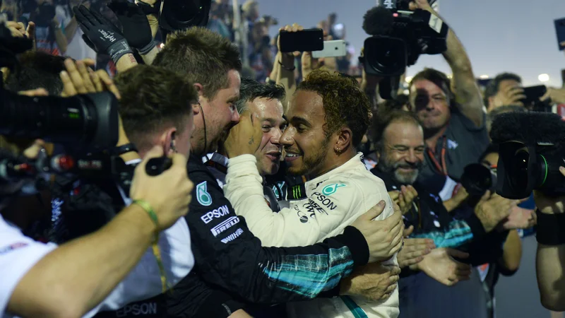 Fotografija: Lewis Hamilton je zmago v Singapurju najprej proslavil s svojimi mehaniki. Foto: AFP