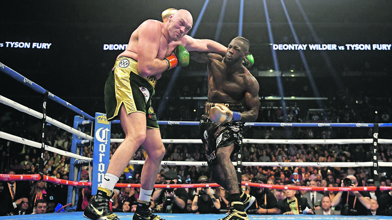 Fotografija: Ameriški boksarski šampion Deontay Wilder (desno) je s silovitimi udarci dvakrat spravil na tla svojega britanskega izzivalca Tysona Furyja. FOTO: AP
