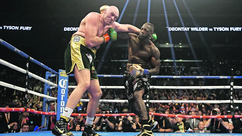 Fotografija: Ameriški boksarski šampion Deontay Wilder (desno) je s silovitimi udarci dvakrat spravil na tla svojega britanskega izzivalca Tysona Furyja. FOTO: AP