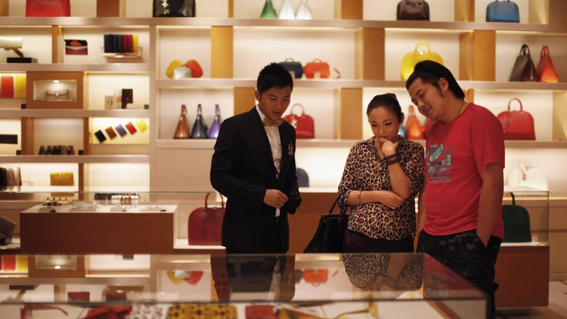 Fotografija: A couple shop at a Louis Vuitton store during Vogue's 4th Fashion's Night Out: Shopping Night with Celebrities in downtown Shanghai September 7, 2012. Louis Vuitton is courting China's wealthy with one-of-a-kind shoes and bags it is branding as unique works of art to reclaim its exclusive cachet in the luxury market. REUTERS/ Carlos Barria (CHINA - Tags: FASHION BUSINESS SOCIETY WEALTH) - RTR37MSO