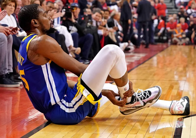Kevin Durant je po vnovični poškodbi nemočno obsedel in se prijel za boleči del. FOTO: Reuters