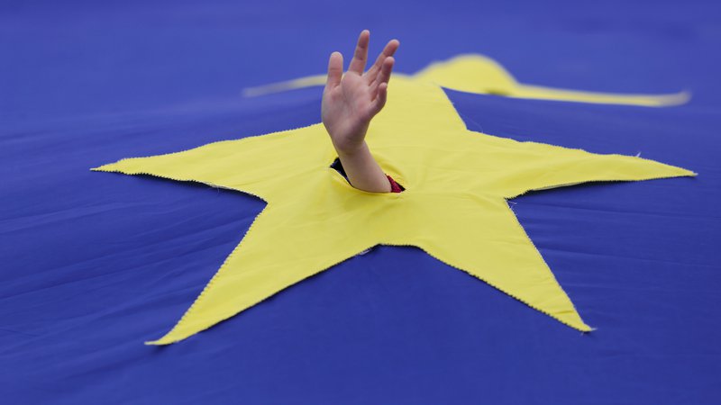 Fotografija: A child waves his hand through a cut made in one of the stars that make up the European Union flag, during a support rally organised to mark the EU's 60th anniversary of the Treaty of Rome in downtown Bucharest, Romania, March 25, 2017. Inquam Photos/Octav Ganea/via REUTERS ATTENTION EDITORS - THIS IMAGE WAS PROVIDED BY A THIRD PARTY. EDITORIAL USE ONLY. ROMANIA OUT. NO COMMERCIAL OR EDITORIAL SALES IN ROMANIA. - RTX32OBG Foto Inquam Photos Reuters