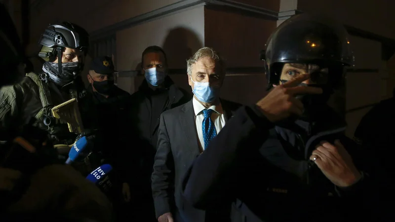 Fotografija: Med protesti se je na ulici pojavil tudi močno zastražen notranji minister Aleš Hojs. FOTO: Matej Družnik