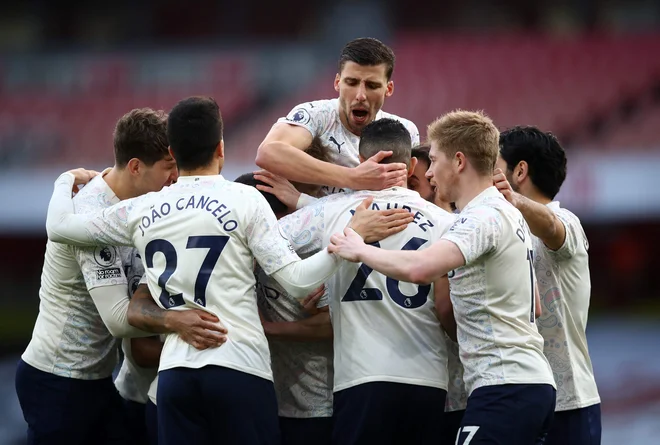 Takole so nogometaši Manchester Cityja obkrožili Raheema Sterlinga, strelca edinega gola v derbiju z Arsenalom. FOTO: Julian Finney/AFP