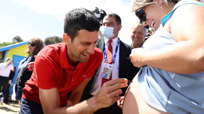 Fotografija: Novak Đoković se je takole včeraj podpisal na trebuh ene od svojih nosečih oboževalk. FOTO: Loren Elliott/Reuters